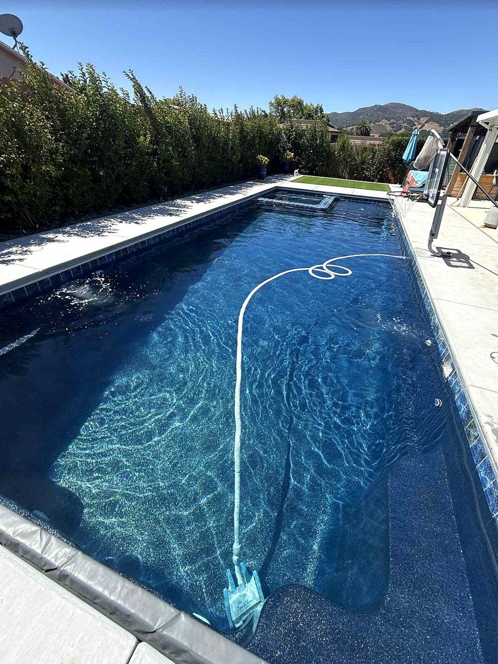 Completed Latham Astoria 16 fiberglass pool, forty feet long with an integrated spa, built by Neighborhood Pool Service